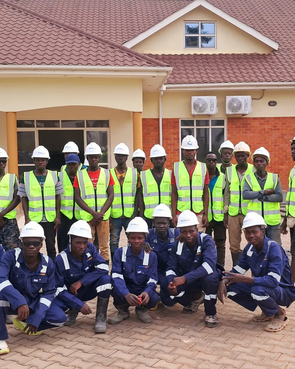 The Tetrabuild site team in hi-vis vests and hard hats outside a completed project building