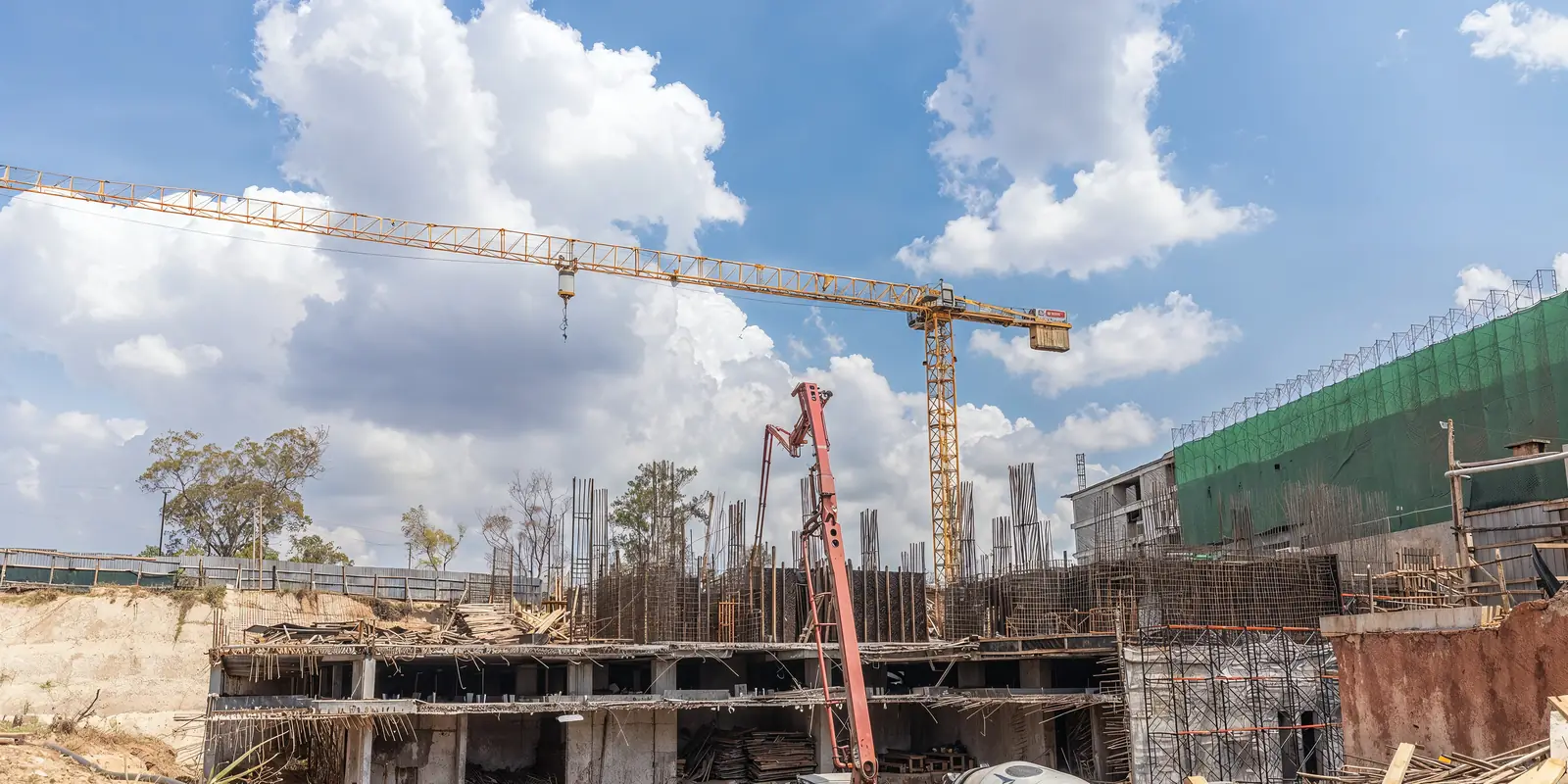 Tower crane, concrete pump and formwork over the reinforced concrete frame of a Tetrabuild building site