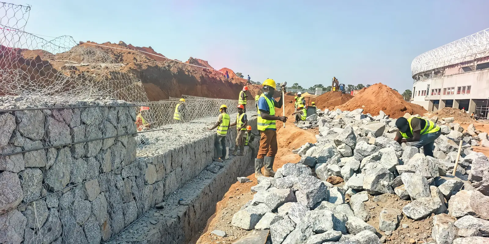 Tetrabuild crew filling stone into gabion baskets at Akii Bua Memorial Stadium, Lira