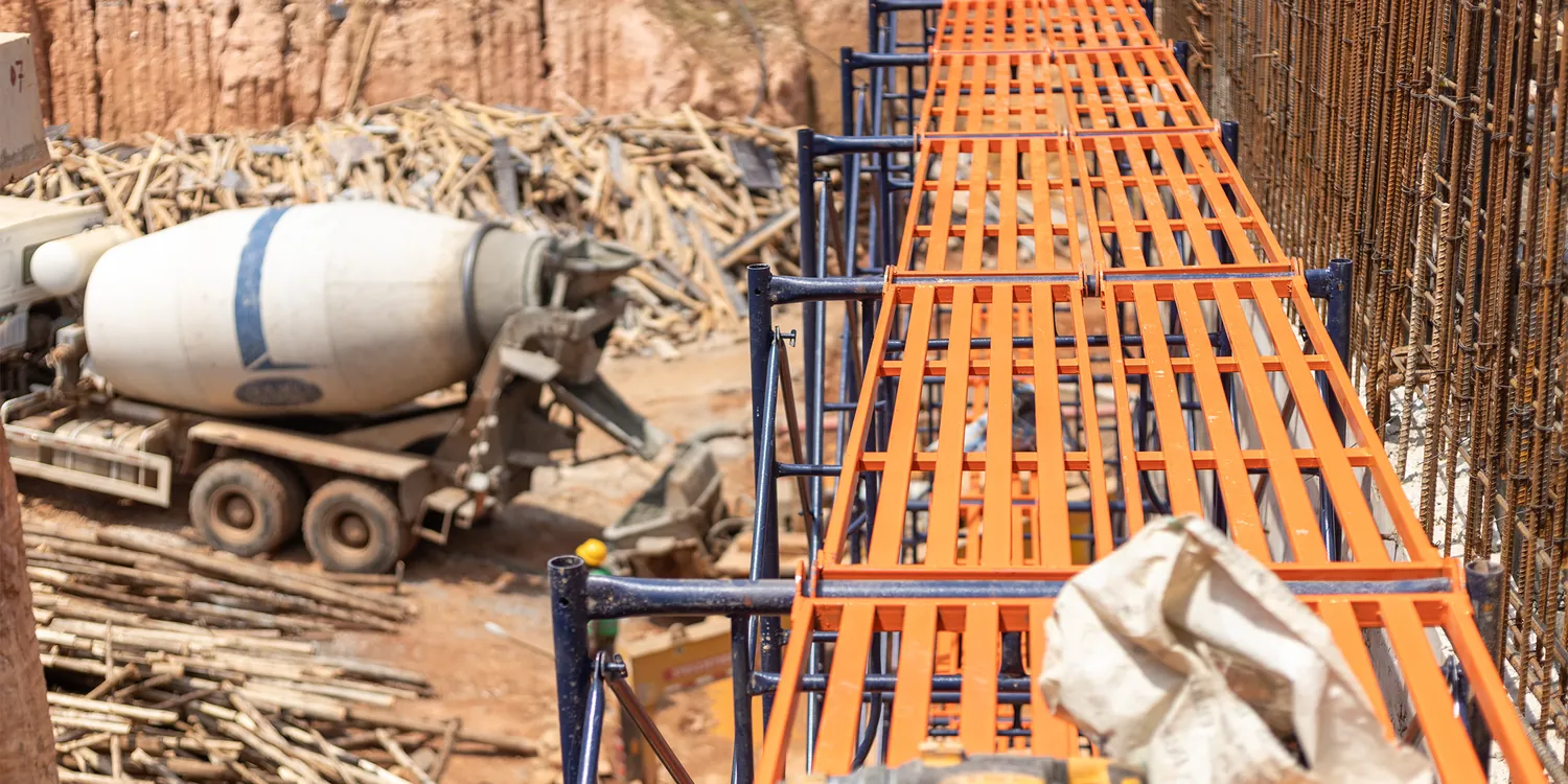 Steel wall formwork lined up beside a concrete mixer truck on a Tetrabuild site