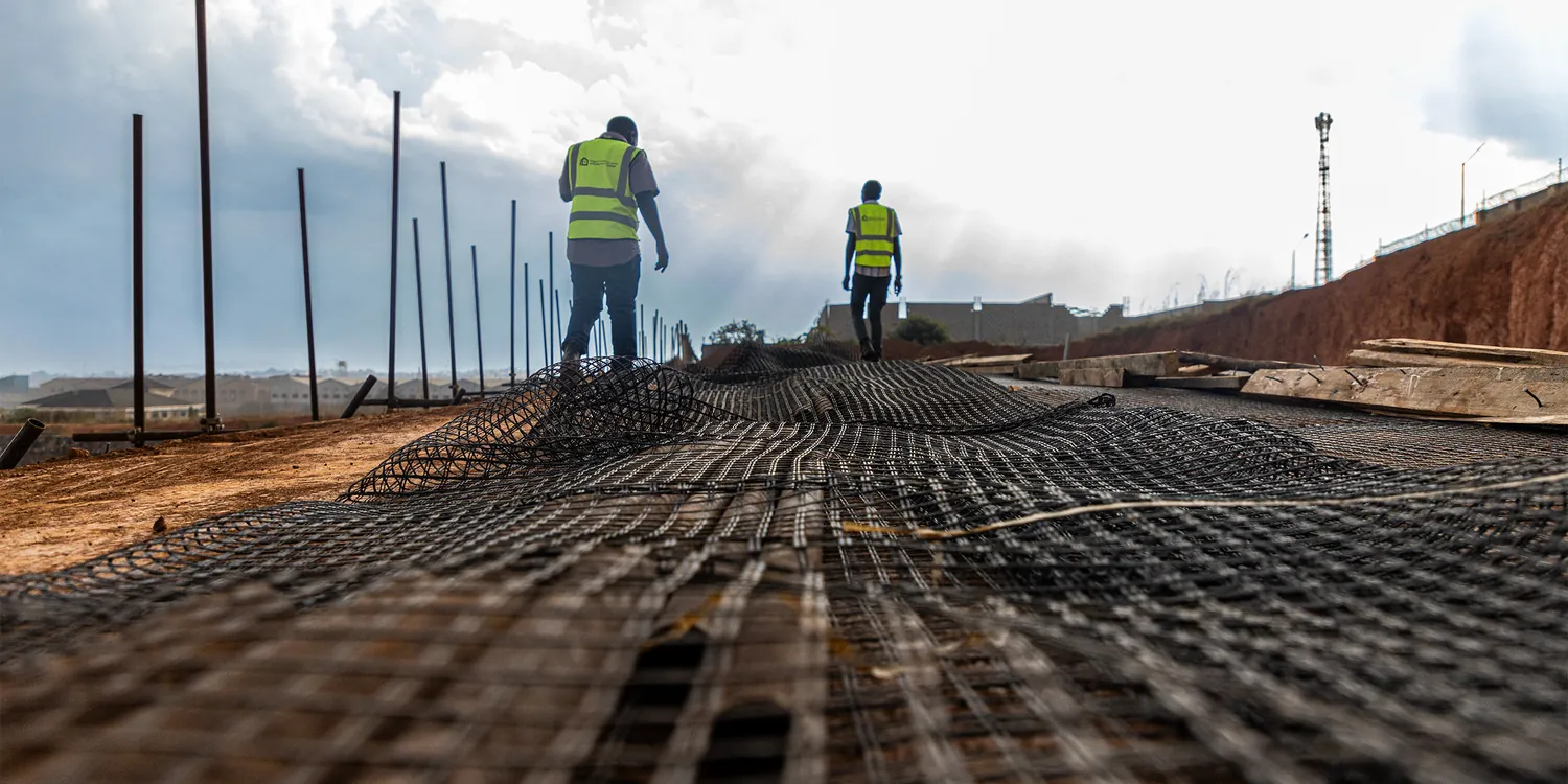 Two Tetrabuild workers on a reinforcement mesh deck laid out across a large slab
