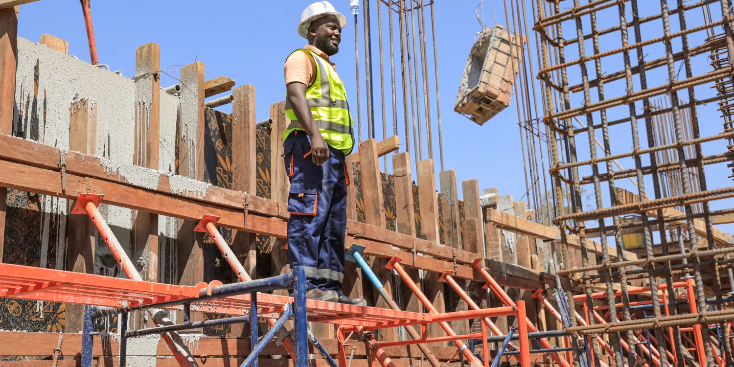 Tetrabuild worker on the formwork deck as a crane lowers materials into the reinforcement cage