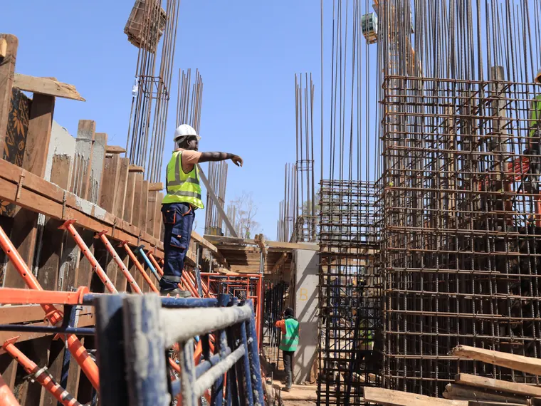 Tetrabuild site engineer directing work from the formwork deck above a reinforced concrete wall