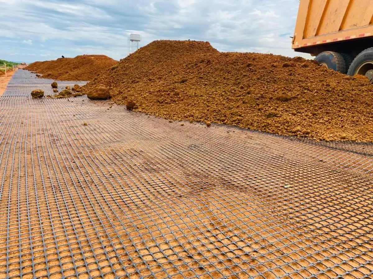 Geogrid reinforcement laid out across compacted fill for a mechanically stabilised earth retaining wall