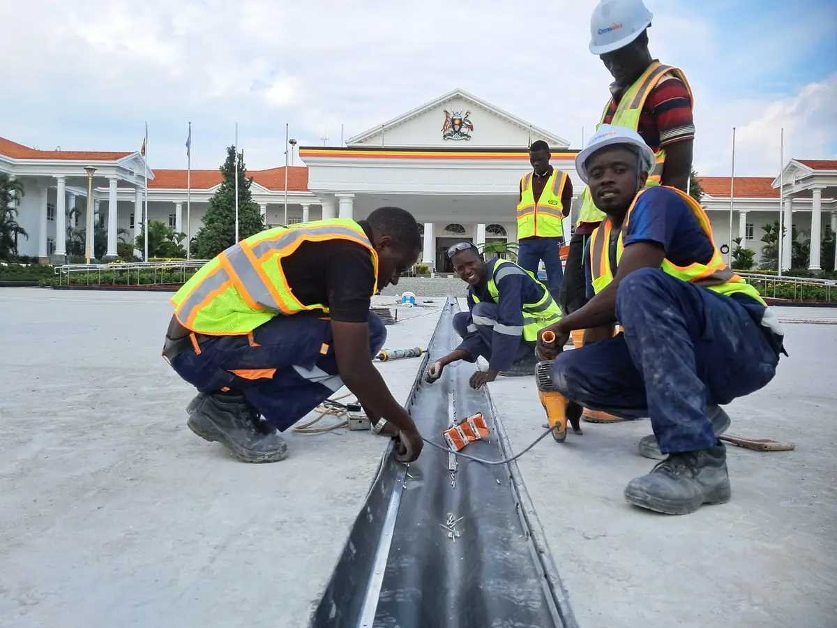 Tetrabuild crew installing PVC water bar into a movement joint in front of State House Entebbe