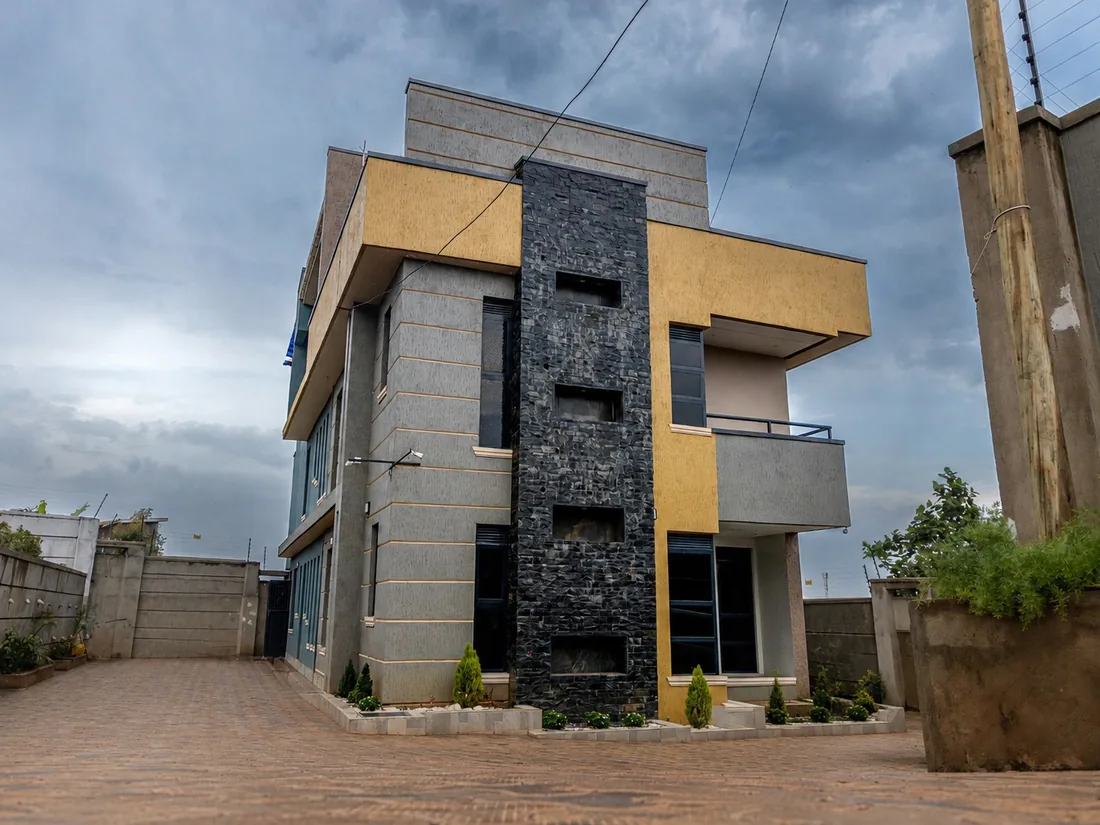 A completed three-storey residential building with finished driveway